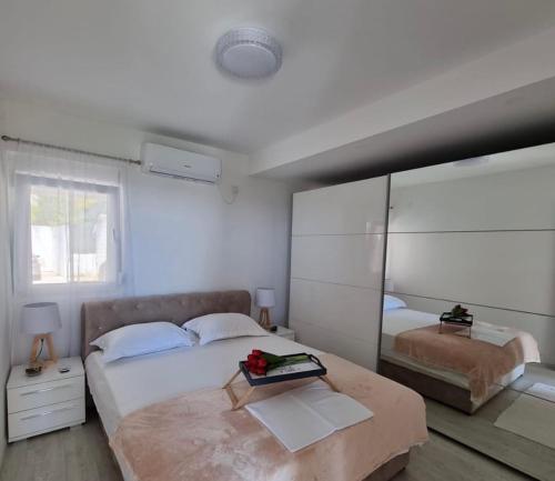 sypialnia z dużym łóżkiem i lustrem w obiekcie Apartman Marija w mieście Bečići