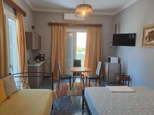 a room with a bed and a table and a kitchen at Dimitris place near Athens airport in Koropi