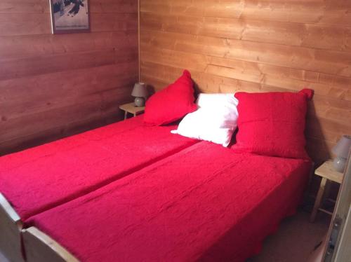 - une chambre avec un lit rouge et 2 oreillers rouges dans l'établissement Paradiski pied des pistes vallandry, à Landry