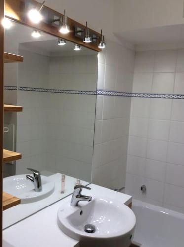 une salle de bain blanche avec un lavabo et un miroir dans l'établissement Paradiski pied des pistes vallandry, à Landry