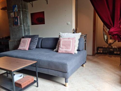 un canapé bleu dans un salon avec une table dans l'établissement Château d'Uriage - Duplex avec terrasse privative, à Saint-Martin-dʼUriage