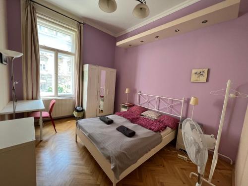 ブダペストにあるJazzy Vibes Parliament Rooms and Ensuitesの紫の壁のベッドルーム1室、赤い枕付きのベッド1台が備わります。