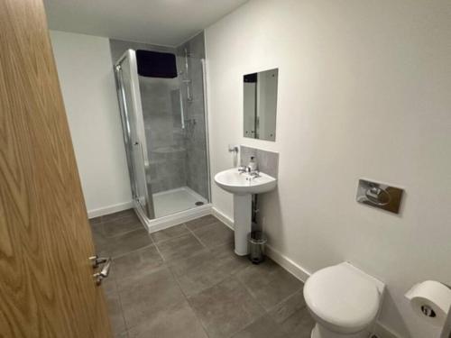 a bathroom with a toilet and a sink and a shower at XL 2 Bed Central MCR Apt Sleeps 7 in Manchester