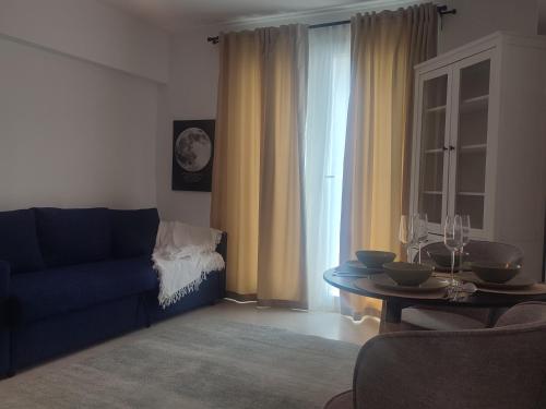 a living room with a blue couch and a table at The Moon Residence in Bucharest
