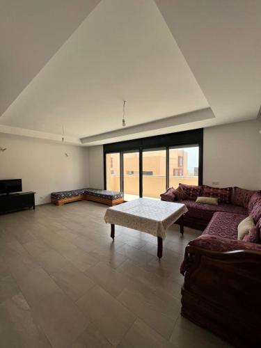 ein großes Wohnzimmer mit einem Sofa und einem Tisch in der Unterkunft Duplex Taghazout Bay in Taghazout
