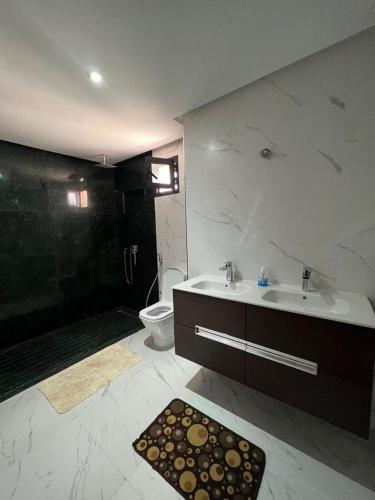 ein Bad mit einem Waschbecken, einer Dusche und einem WC in der Unterkunft Duplex Taghazout Bay in Taghazout
