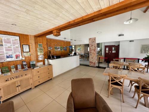 un ristorante con tavolo, sedie e bancone di Appartement T3 avec jardin et piscine - Luz Saint Sauveur, Val de Roland a Luz-Saint-Sauveur