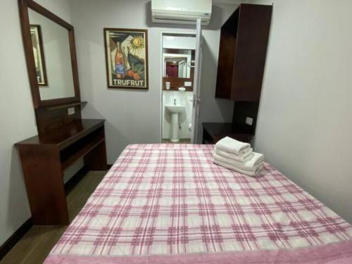 a bedroom with a bed with a plaid blanket at Sliema - Double Room in Sliema