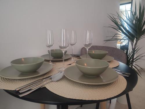 a table with plates and bowls and wine glasses at The Moon Residence in Bucharest