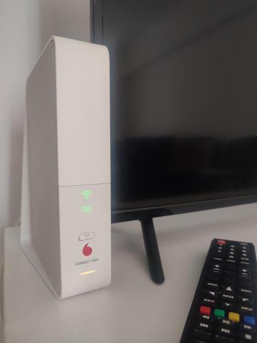 a white wii console sitting next to a remote control at The Moon Residence in Bucharest