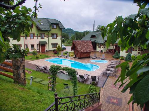 un patio trasero con piscina y una casa en Emerald House en Mykulychyn