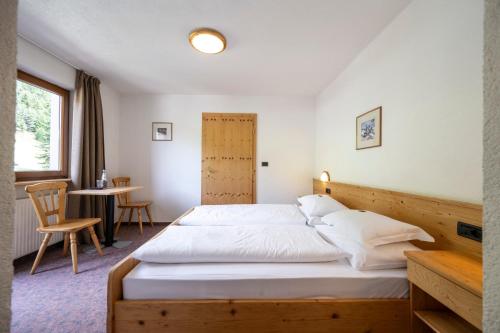 a bedroom with a large bed with a wooden headboard at Berghotel Schlemmer in Bressanone