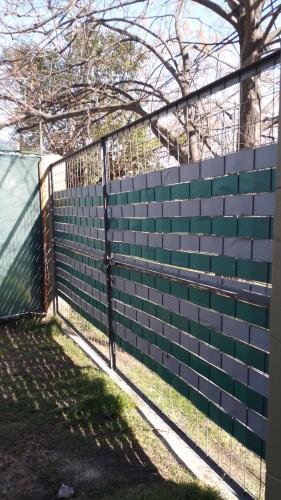 a fence with a green and white wall at LO DE CHUCHO in Don Torcuato