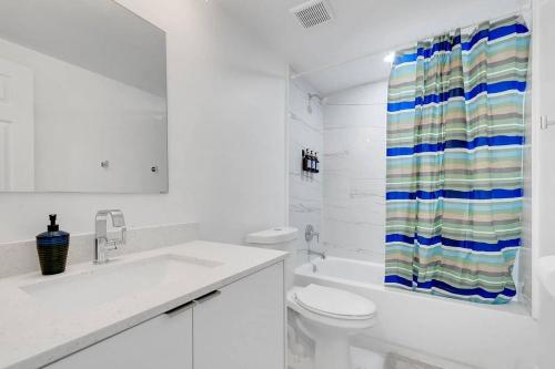 a bathroom with a toilet and a shower curtain at BRAND NEW Designer's Office Home #8 in Miami