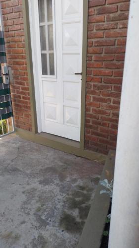 a white garage door with a brick wall at LO DE CHUCHO in Don Torcuato