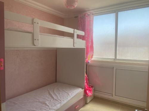 a small bedroom with a bunk bed and a window at Appartement meublé Tanger Houara in Tangier