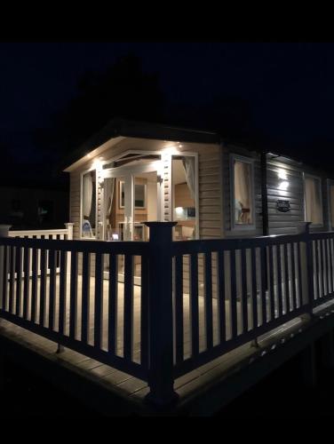 a small house with a porch at night at Tenby - Kiln Park caravan hire in Pembrokeshire