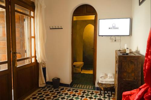 a hallway with a bathroom with a toilet and a door at Riad Dar Pierre in Fès