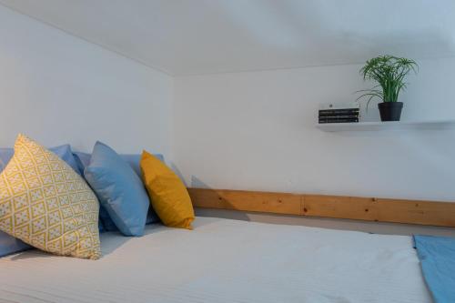 a couch with pillows and a shelf on the wall at Secondin Apartment by Wonderful Italy in Turin