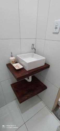 a white sink on a wooden shelf in a bathroom at Temporada Casa dos Paiva in Barreirinhas