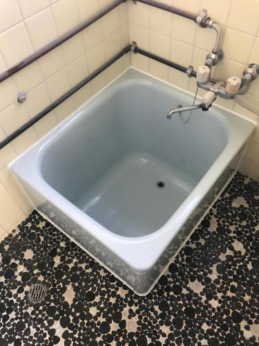 a large bath tub in a bathroom with a tile floor at 魚の宿【海と西】 