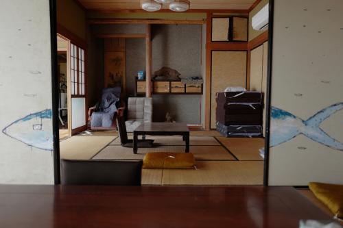a living room with a table and a couch at 魚の宿【海と西】 