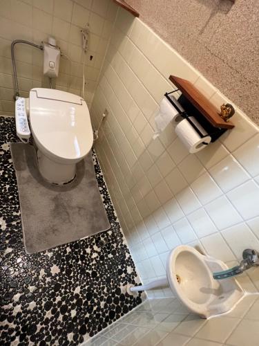 a bathroom with a toilet and a tiled floor at 魚の宿【海と西】 