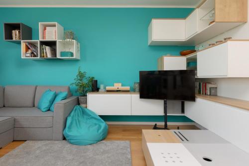 uma sala de estar com um sofá e uma televisão em Metro Wilanowska Apartment with Parking by Renters em Varsóvia