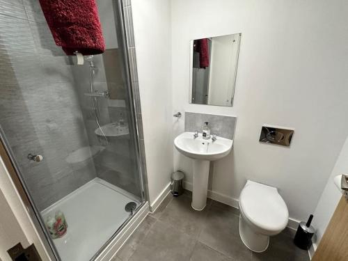 uma casa de banho com um chuveiro, um WC e um lavatório. em Stylish Studio for 2 MCR+Balcony em Manchester
