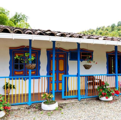 une maison avec des portes bleues et des fleurs devant elle dans l'établissement Posada Campestre Agua Bonita, à Pueblorrico