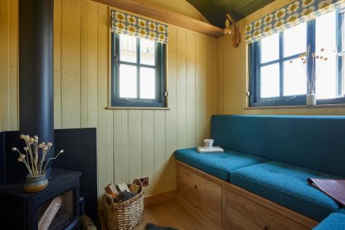 a blue bench in a room with two windows at Rufflets St Andrews in St. Andrews
