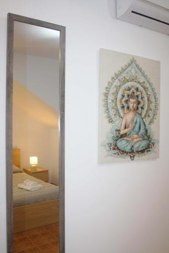 a painting hanging on a wall next to a mirror at Lugar dos Louros 1 in Estreito da Calheta