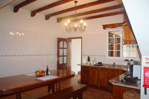 een keuken met een tafel en een aanrecht bij Lugar dos Louros 1 in Estreito da Calheta