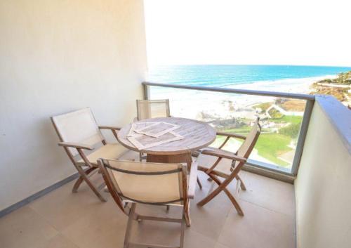 stół i krzesła na balkonie z widokiem na ocean w obiekcie דירה עם נוף לים הרצליה w mieście Herzliya