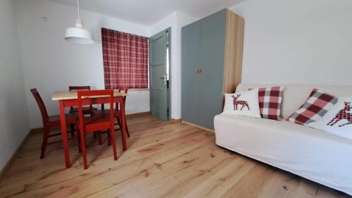 a living room with a table and a white couch at Staguda 59 in Sottoguda
