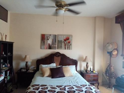 a bedroom with a bed with a ceiling fan at Espacio familiar Poma in Machala