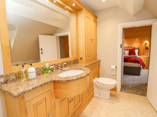 uma casa de banho com um lavatório e um WC em Manor Farm em Cheltenham