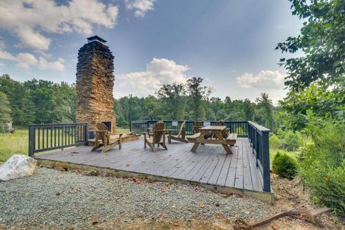 a wooden deck with a picnic table and a fire tower at Rustic Baileys Retreat Cabin Near Wineries! in Crozet