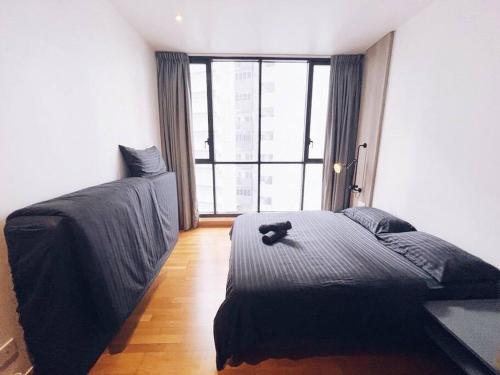 a bedroom with a black cat sitting on a bed at [PROMO]Connected train 2 Bedroom (ABOVE MALL)8 in Kuala Lumpur