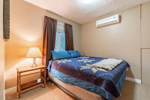 1 dormitorio con cama, lámpara y ventana en Waterfront - Kawartha Lakes, en Kawartha Lakes