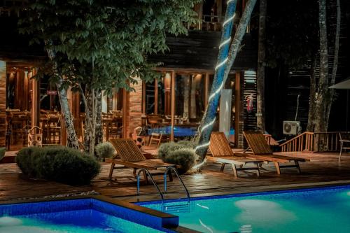 a swimming pool with two chairs and a house at De Foret in Havelock Island