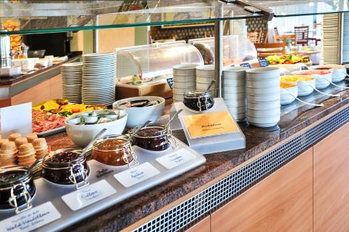a buffet line with plates and bowls of food at ACHAT Hotel Braunschweig in Braunschweig