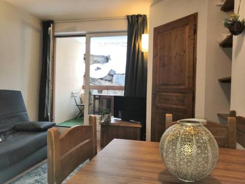 - un salon avec une table en bois et un vase dans l'établissement Très Joli T2 aux pieds des pistes avec Balcon, à Orcières