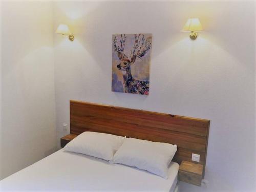 1 dormitorio con 1 cama y una pintura en la pared en Très Joli T2 aux pieds des pistes avec Balcon en Orcières