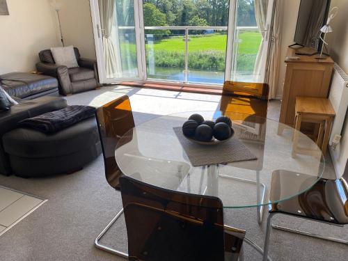 a living room with a glass table with spheres on it at River Penthouse Little Paxton - 75 Skipper Way in Saint Neots