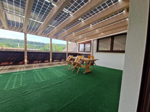 a room with a table and chairs on a green floor at Hotel Platzhirsch in Gaggenau