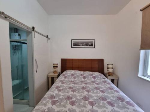 1 dormitorio con 1 cama en una habitación con ventana en LINDISSIMO IPANEMA, 2 SUÍTES, en Río de Janeiro