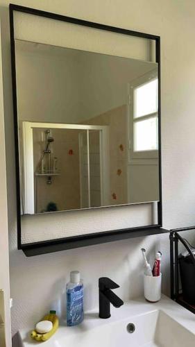 La salle de bains est pourvue d'un lavabo et d'un grand miroir. dans l'établissement Mimizan Surf & Beach House 250m océan + forêt, à Mimizan