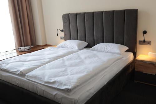 a large white bed with a large headboard in a bedroom at Готель Карпатія in Mukacheve