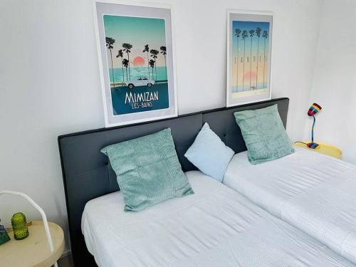 two beds in a bedroom with two pictures above them at Mimizan Surf & Beach House 250m océan + forêt in Mimizan